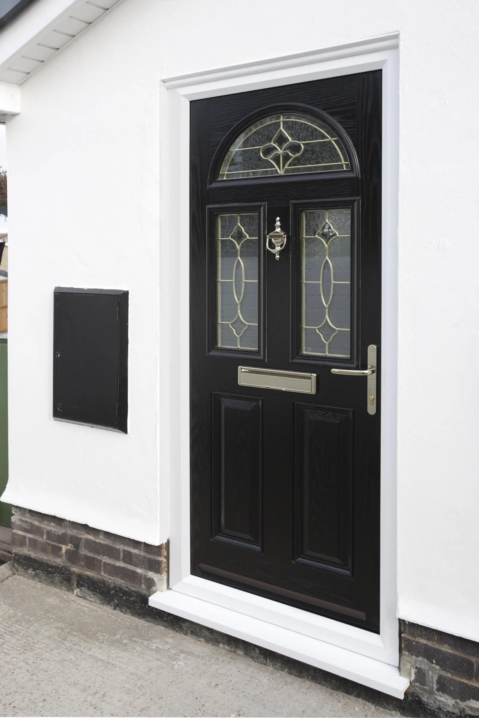 Black composite door with fan-light and leaded glass on a white rendered house